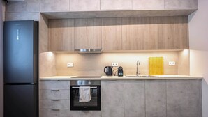 A modern kitchen with a built-in oven, a coffee maker, and a sink. - Stylish 2BR Exarchia l King Bed & Desk (Exarchia)