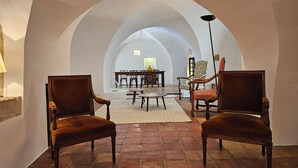 An arched room with two wooden chairs, a table, and a lamp. - Beautiful Village House (Lauris)