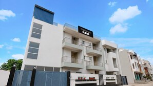 A multi-story townhouse with a sign indicating it is serviced by OYO. - Deluxe Pine Villa (Lucknow)