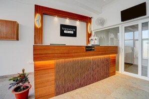 Un comptoir d’accueil avec une pancarte indiquant que le service est assuré par OYO.