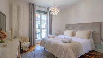 Una camera da letto con un letto grande, una lampada a sospensione, vista all'esterno e una finestra con tende.