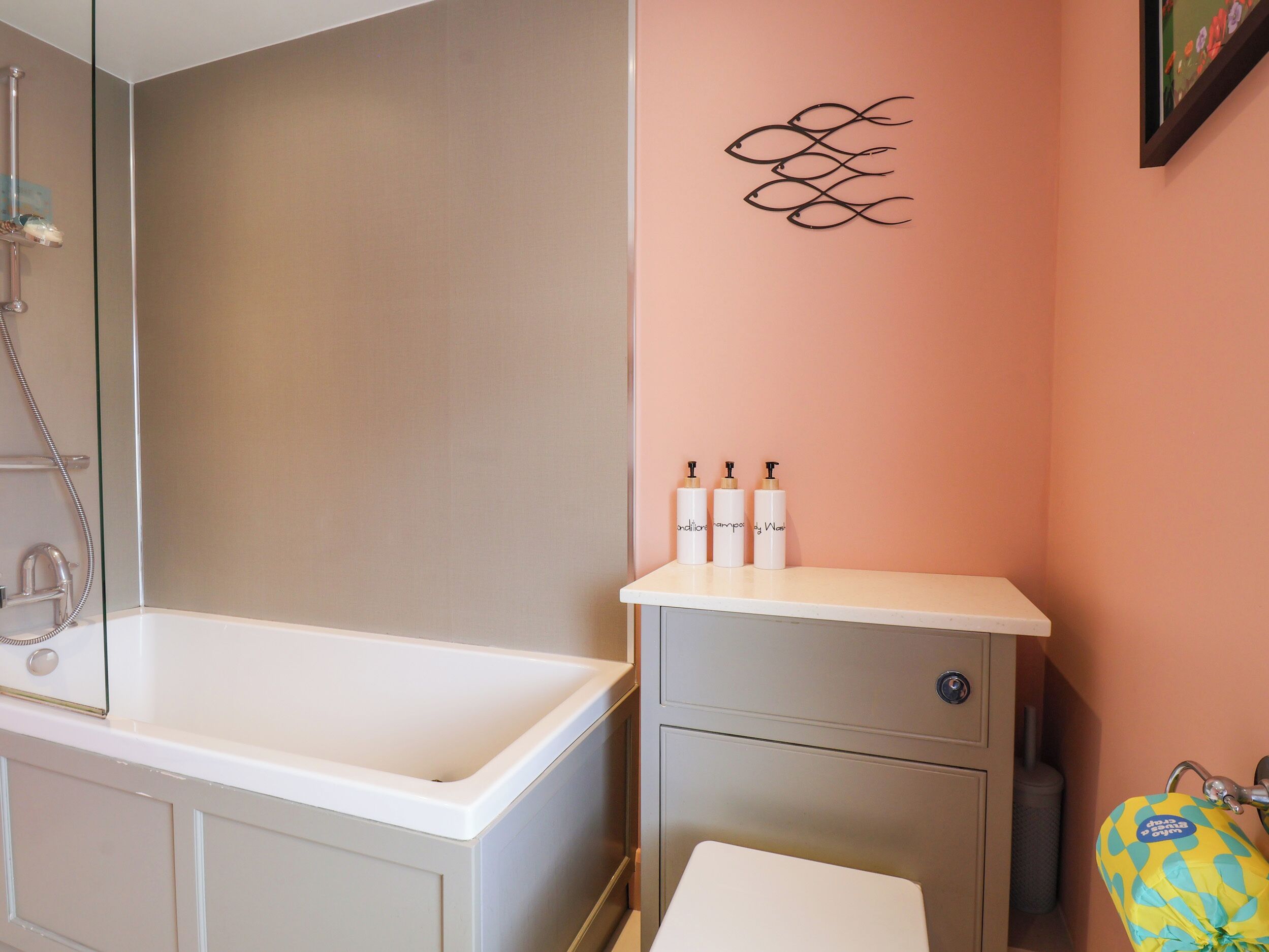 A bathroom with a bathtub, a sink with toiletries, and a shower.