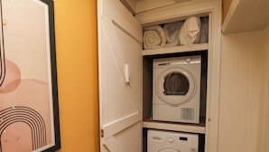 A laundry room with two stacked washing machines and a shelf above them. - The Braes (Redcar)