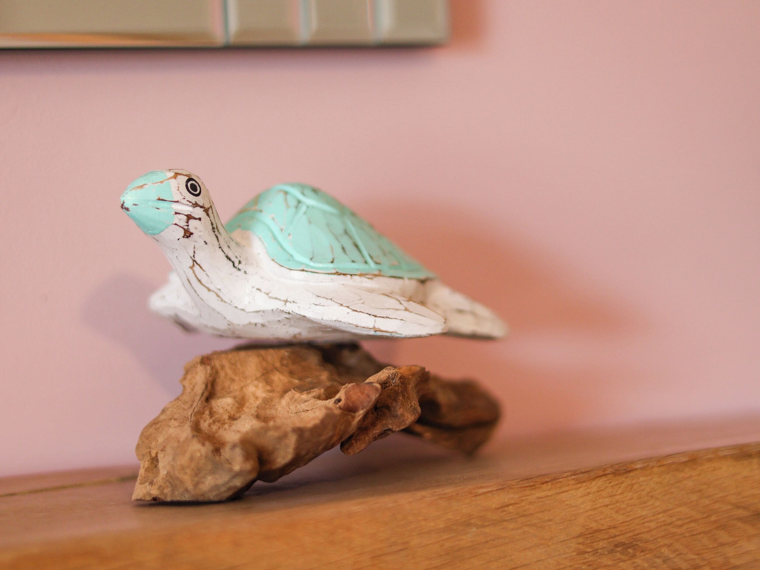 A small turtle figurine on a wooden base.