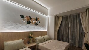 Ein modernes Hotelzimmer mit zwei Betten, einer Wanddekoration, einem Fenster mit Vorhängen und einem Holzboden.