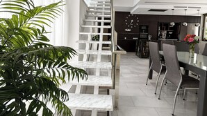 Ein modernes Interieur mit Treppe, Essbereich und Küche.
