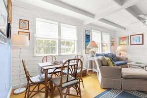 Ein Zimmer mit Esstisch, Stühlen, einer Couch und einer Lampe.