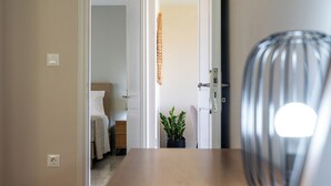 A hallway with a bed, a nightstand, a potted plant, and a door leading to another room. - 3-bedroom eco villa in excellent Dilinata, family / friends friendly (Dilinata)