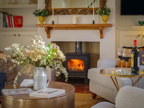 Una sala de estar acogedora con chimenea, una mesa de centro con revistas y un sofá.