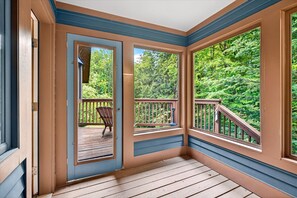 A room with a wooden deck, large windows, and a view of a forest. - Lovely 3 bed 2.5 bath in the heart of Killington (Killington)