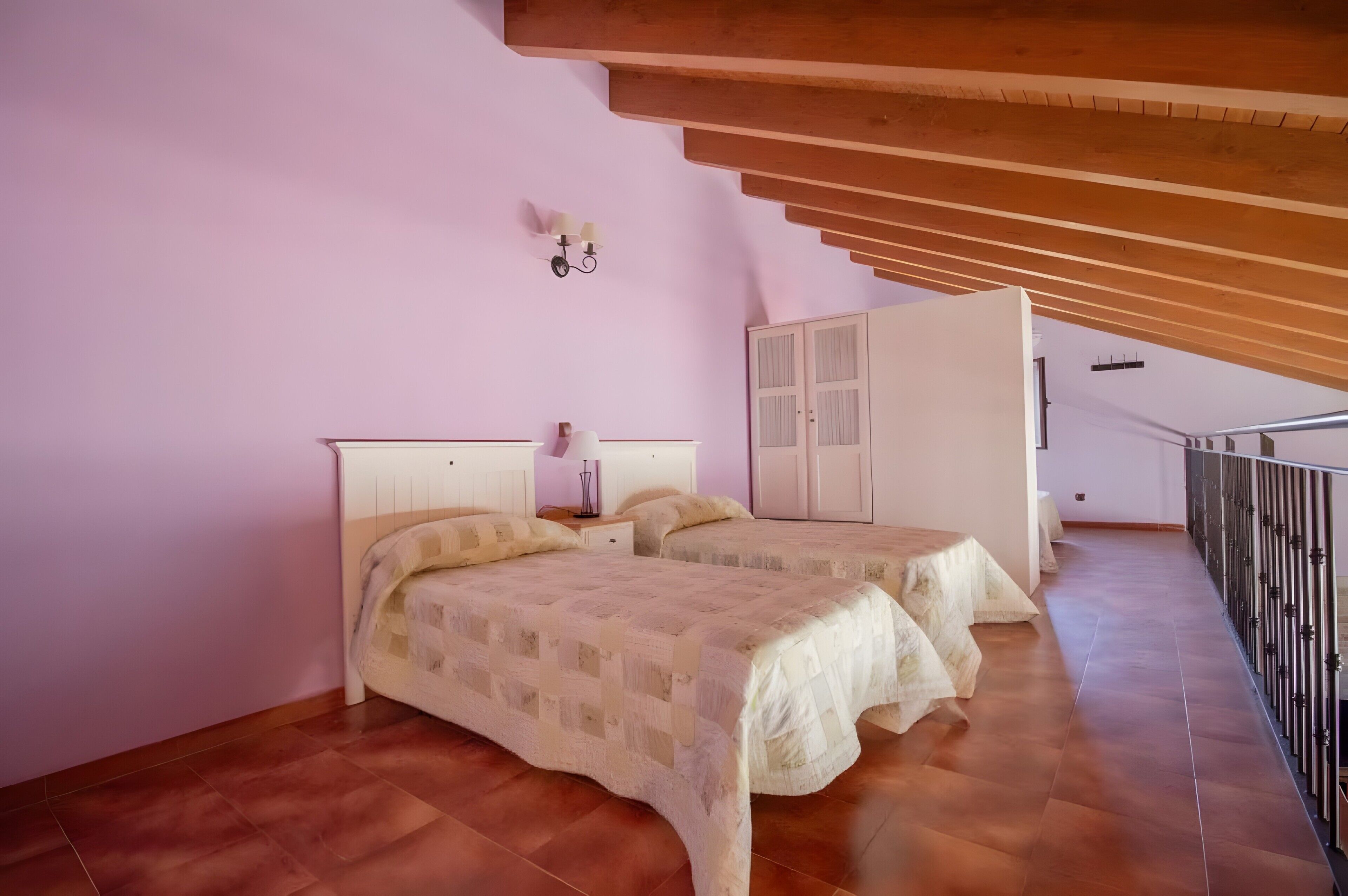 Un dormitorio con dos camas, un armario y una escalera.