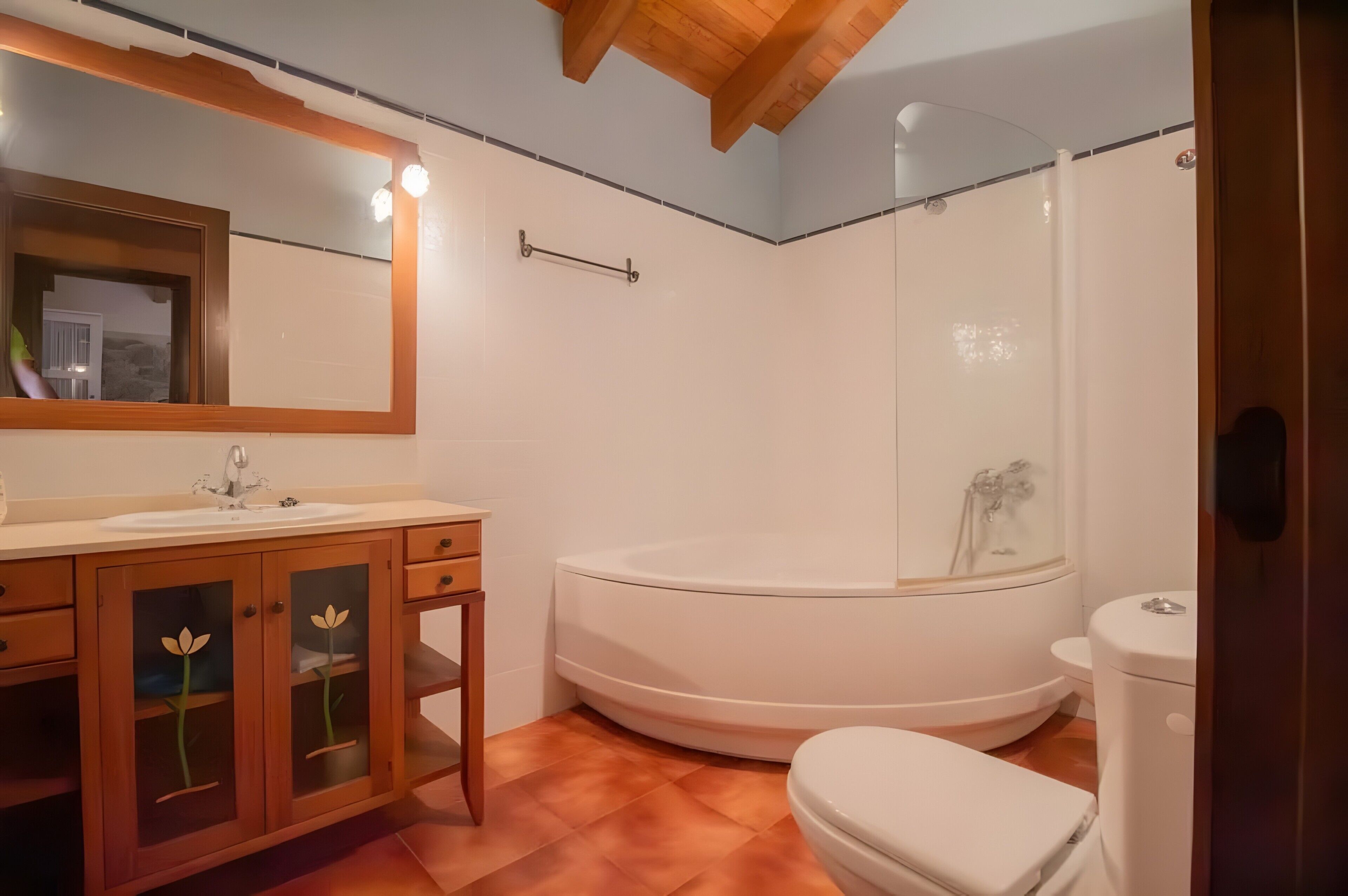 Un bagno con lavandino, mobile lavabo, WC e doccia.
