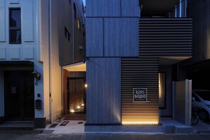 Un edificio moderno con un letrero que dice 'koti soppo' y un coche estacionado afuera.