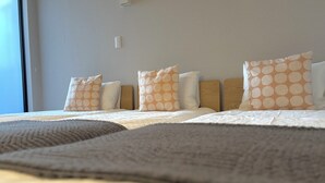 A hotel room with a large bed, multiple pillows, a headboard, and a window. - Koti Sopo Universal Bay 2 by Liaison (Osaka)