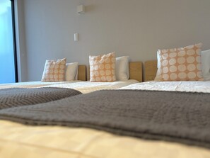 Une chambre d’hôtel avec un grand lit, plusieurs oreillers, une tête de lit et une fenêtre.