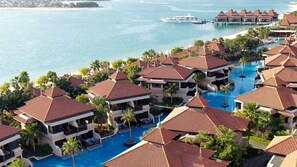Ein Resort mit mehreren Gebäuden, einem zentral gelegenen Pool und Blick auf das Meer.