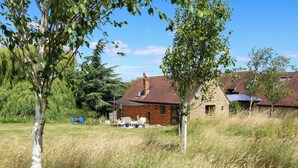 A rustic house with a brick exterior, a sloped roof, and a small porch area.