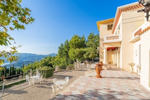A courtyard with outdoor seating, a large vase, and a view of the landscape. - Les Hauts de Cassis in Cassis (Cassis)