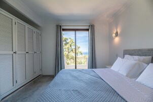 Un dormitorio con cama, cortinas, una ventana con vistas y un armario.