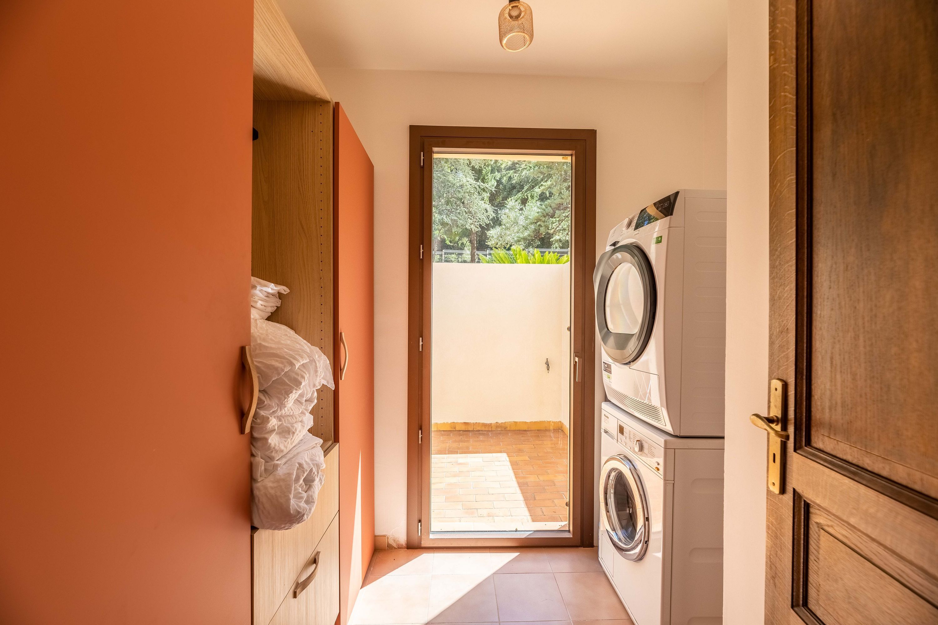 A laundry room with a washing machine, dryer, and a door leading to an outdoor area.