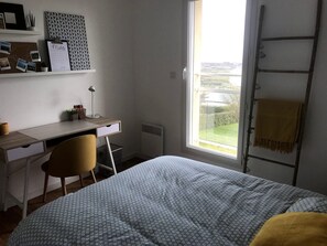 A bedroom with a bed, a desk, a chair, a window with a view, and a ladder. - Panoramic Holiday Villa With Sea Views in Telgruc-sur-mer (Telgruc-sur-Mer)