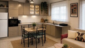 Una cocina compacta con comedor, refrigerador, horno y pileta.
