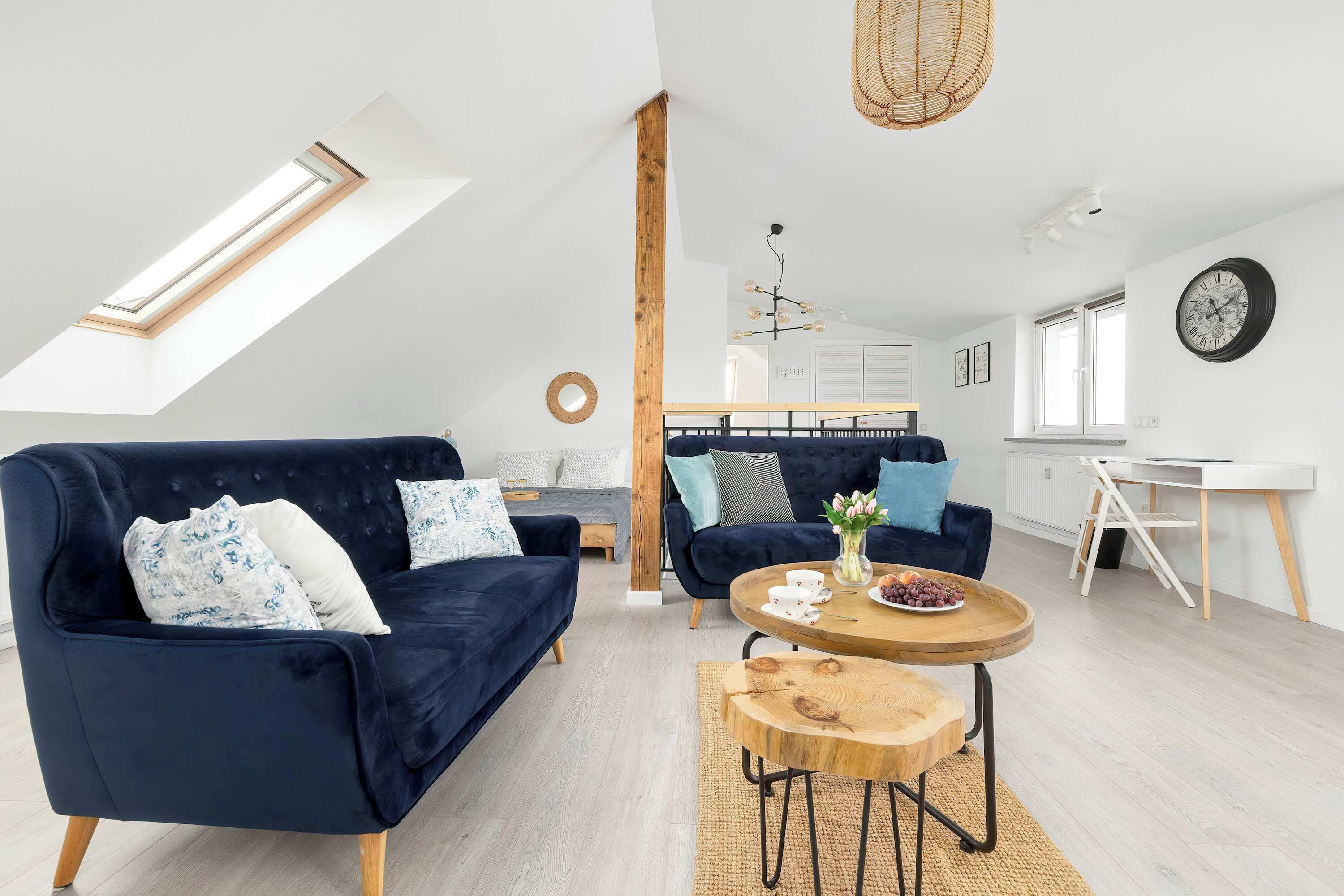 Bright and spacious living room with comfortable blue sofas, a coffee table, and plenty of natural light.