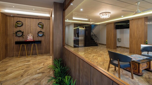 Um interior moderno com um balcão de recepção, área de estar e uma escadaria.