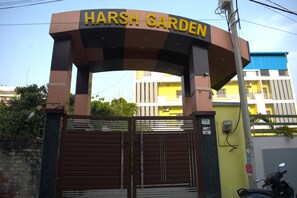 Una entrada con reja y un letrero que dice 'HARSH GARDEN'.