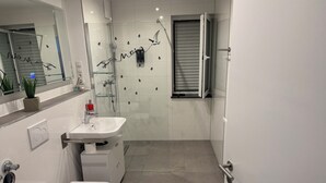 A modern bathroom with a toilet, sink, shower, and a window with blinds. - Modern Vacation Rental Near Phandtasialand: A Short Getaway 2 (Weilerswist)