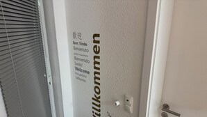 A door with a 'Welcome' sign in multiple languages, a handle, and a lock. - Modern Vacation Rental Near Phandtasialand: A Short Getaway 2 (Weilerswist)