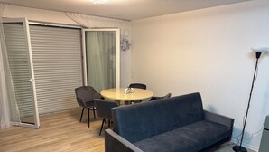 A modern living room with a sofa, a round table, and chairs. - Modern Vacation Rental Near Phandtasialand: A Short Getaway 2 (Weilerswist)
