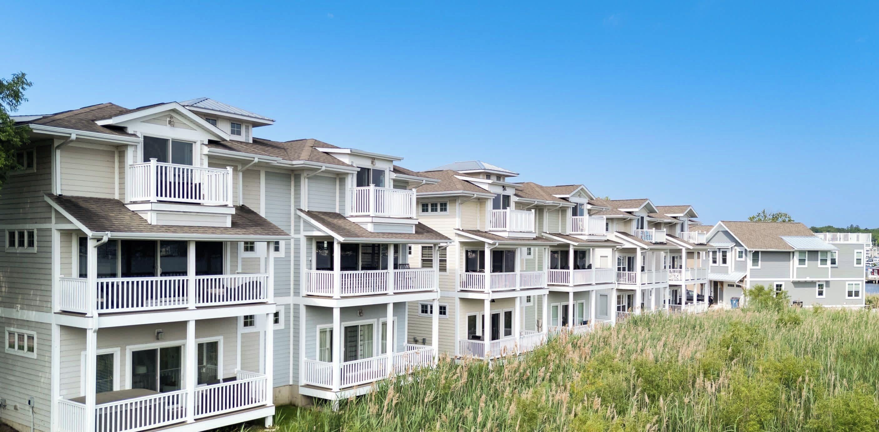 A row of multi-story residential buildings with balconies, likely a condominium or apartment complex.
