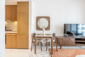 Un espacio habitable moderno con comedor, cocina y mueble de entretenimiento.