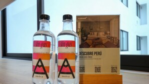 Dos botellas de 'sin-gas' sobre una superficie de madera, con un folleto al fondo.