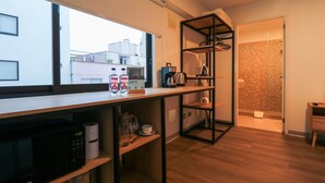 Una cocina moderna con un ventanal grande, una cafetera y un microondas.