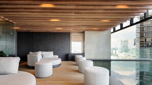 A modern interior with a wooden ceiling, a black wall, and a glass railing overlooking a cityscape. - w Amazing Loft in the Heart of Juarez (Mexico City)