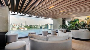 A modern rooftop lounge with a city view, wooden ceiling, and comfortable seating. - w Amazing Loft in the Heart of Juarez (Mexico City)