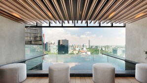 A modern room with a city view, a glass pool, and three round seating areas. - w Amazing Loft in the Heart of Juarez (Mexico City)