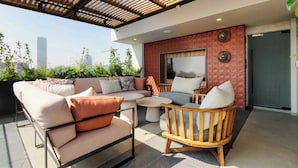 A rooftop terrace with outdoor seating, a large window, and a city view. - w Polished 1BR w Balcony in Tabacalera (Mexico City)