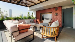 A rooftop terrace with outdoor seating, a large window, and a city view. - w Enchanting Loft w Balcony in Tabacalera (Mexico City)