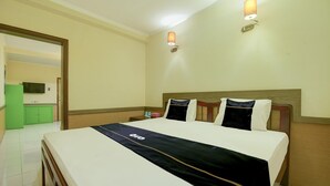 A hotel room with a bed, bedside tables, a TV, and a green cabinet. - Family Luxury Suite W/free Wifi and Parking (Makassar)