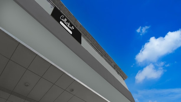 Um edifício com uma placa que diz 'Collection Company Services' e um céu azul claro com nuvens.
