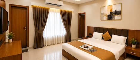 A modern hotel room with a large bed, bedside tables, a flat-screen TV, and a ceiling fan.