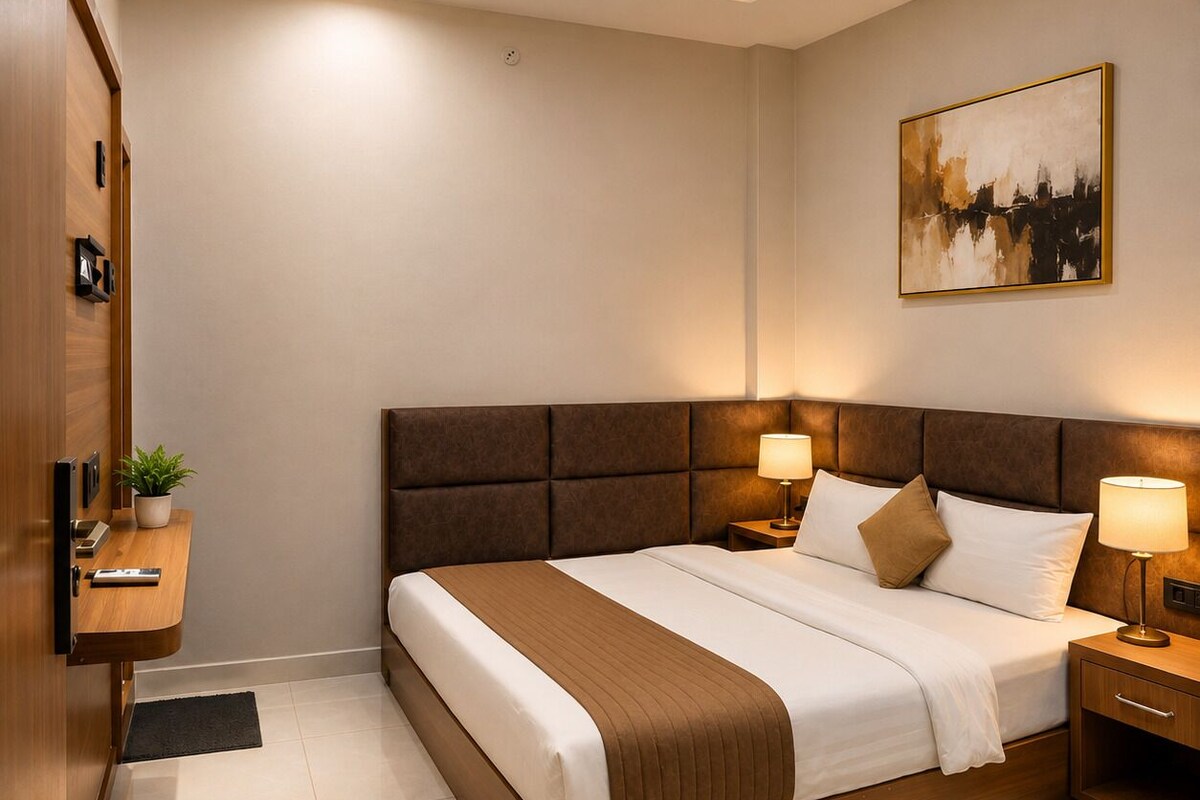 A modern hotel room with a large bed, bedside tables, a wall-mounted painting, and a wooden wardrobe.