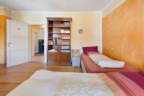 A bedroom with a bed, a wardrobe, and a small table with a lamp. - Apartment 'Casa Avisio' with Private Garden, Wi-Fi and Ski Slopes Nearby (Castello-Molina di Fiemme)