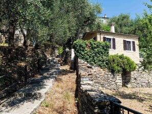 A stone staircase leading to a stone building with a small garden area. - Casetta Pantasina by Interhome (Pantasina)
