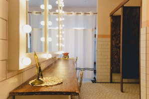 A room with a long wooden table, a mirror with lights, and a patterned wall. - HISTORIC 1945 SCHOOLHOUSE. 4700 sq. ft. of luxury five minutes from Lake Fork. (Como)