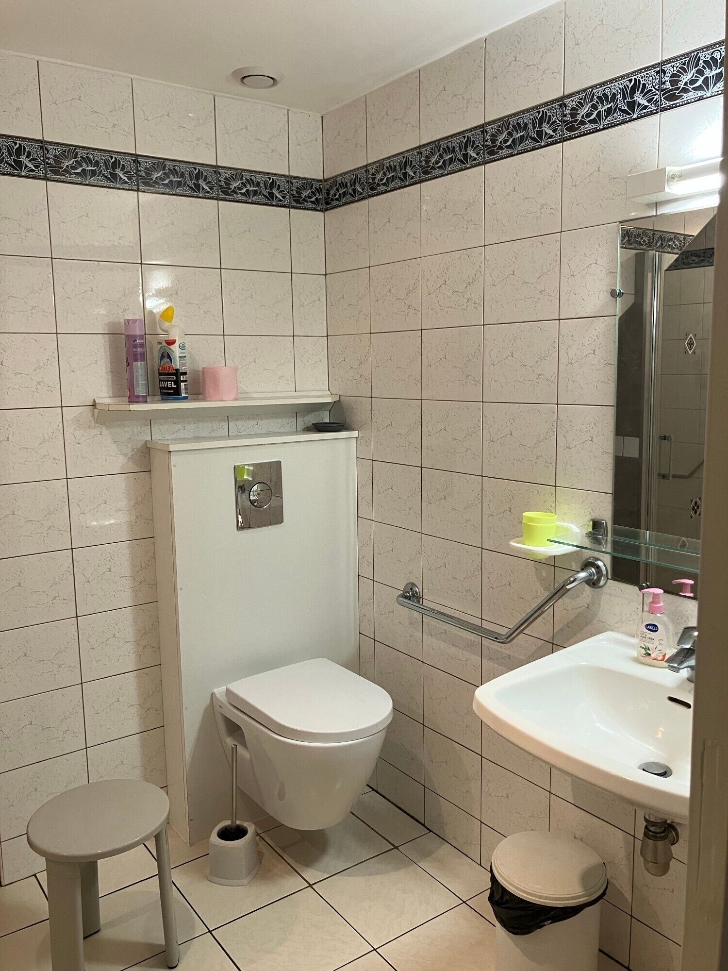 Un baño con inodoro, bidé, lavamanos y cabina de ducha de vidrio.