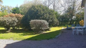 A gravel driveway leading to a building with outdoor seating. - Accommodations in St. Bonnet Tronçais (Saint-Bonnet-Tronçais)